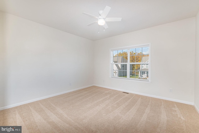 spare room with ceiling fan and carpet