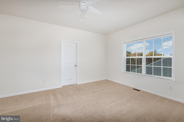 carpeted spare room featuring ceiling fan