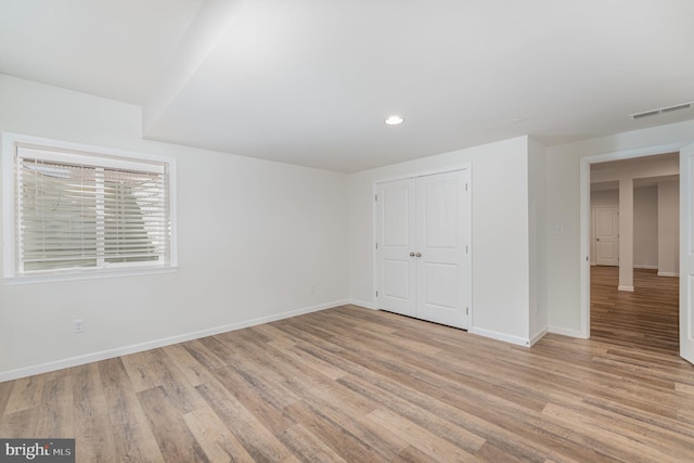 unfurnished bedroom with a closet and light wood-type flooring