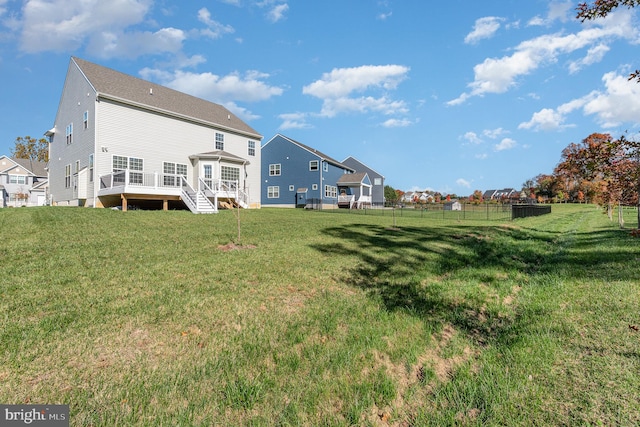 rear view of property with a wooden deck and a yard