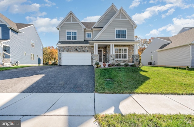 craftsman-style house featuring a front yard, central AC unit, a garage, and covered porch