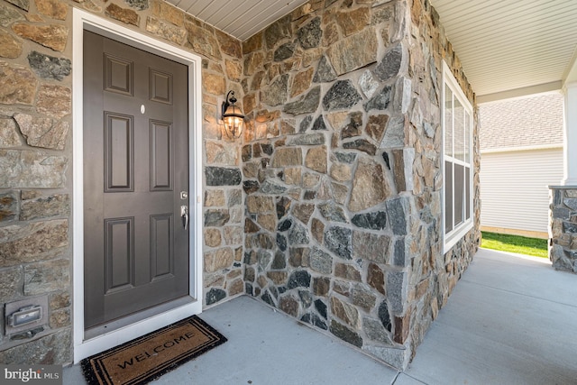 view of exterior entry featuring covered porch