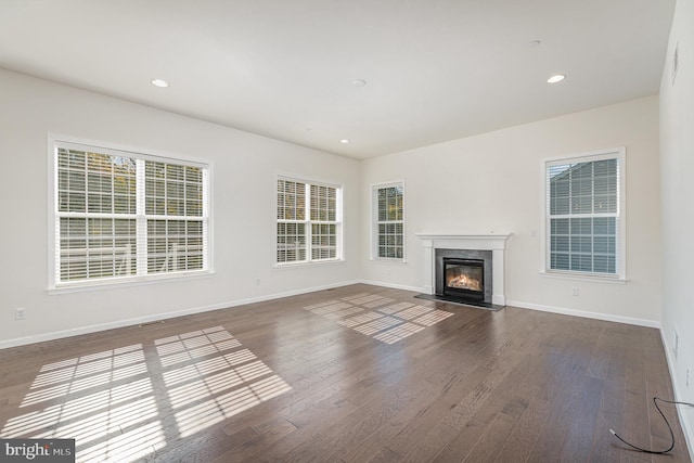 unfurnished living room with dark hardwood / wood-style flooring and a fireplace