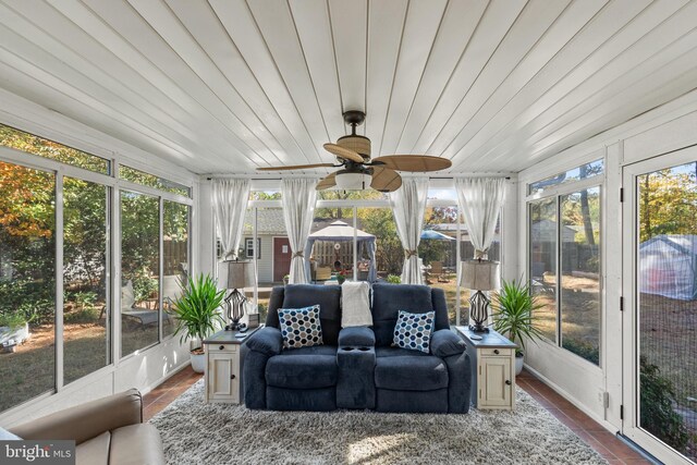 sunroom / solarium featuring ceiling fan, wooden ceiling, and a wealth of natural light