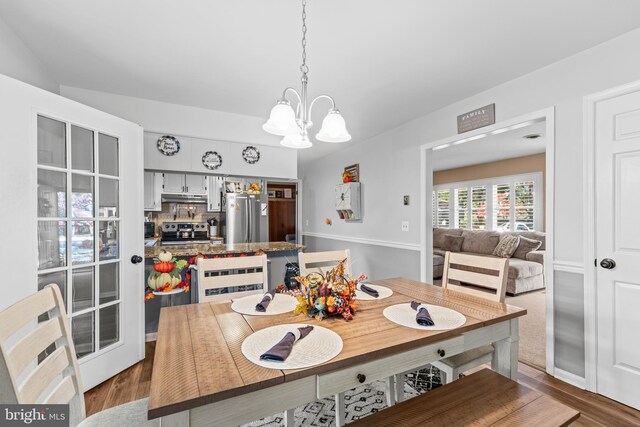 dining room with a notable chandelier and dark hardwood / wood-style flooring