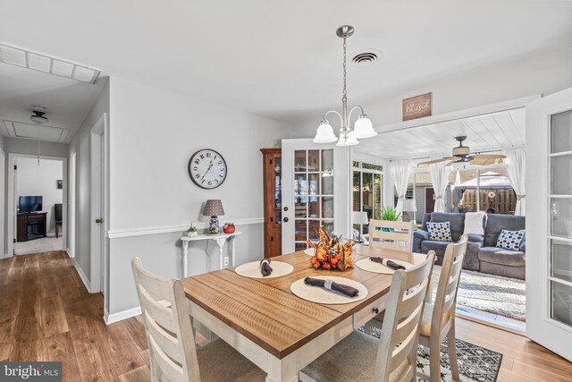 dining room featuring light hardwood / wood-style flooring and ceiling fan with notable chandelier