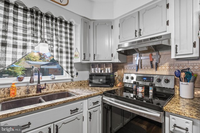 kitchen featuring stone counters, electric stove, tasteful backsplash, and sink