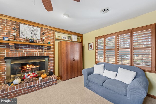 living room featuring ceiling fan, carpet floors, plenty of natural light, and a brick fireplace