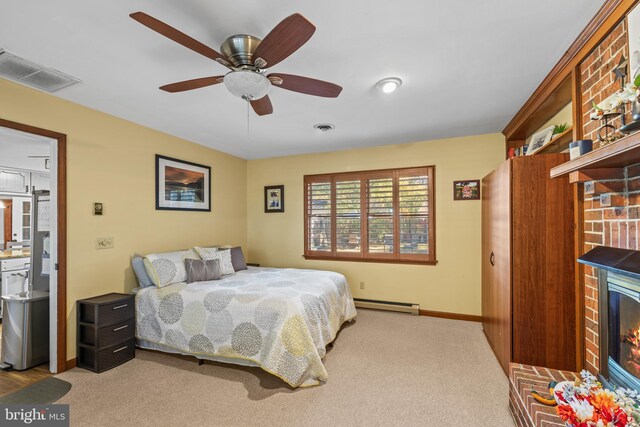 carpeted bedroom featuring ceiling fan, a baseboard heating unit, and a fireplace