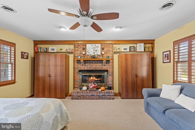 bedroom with carpet, a fireplace, and ceiling fan