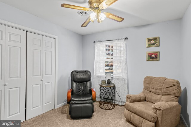 living area with ceiling fan and carpet flooring