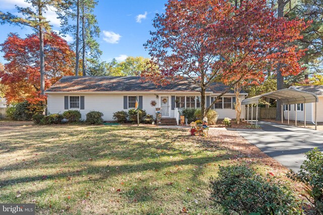 ranch-style home featuring a carport and a front yard