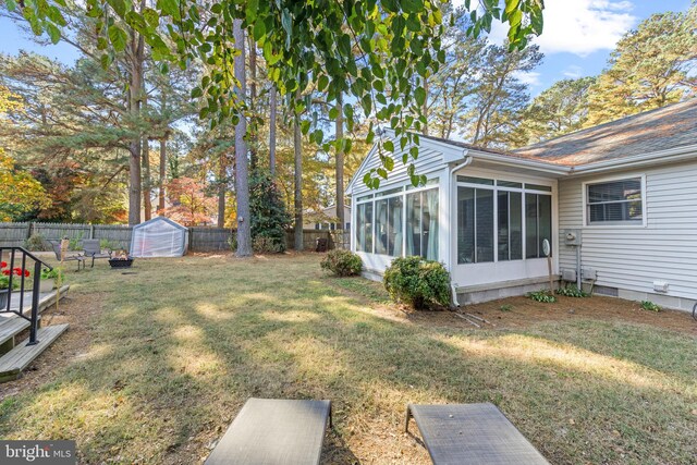 view of yard featuring a shed and a sunroom