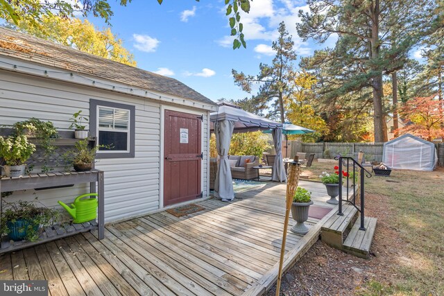 wooden deck featuring a storage unit and outdoor lounge area