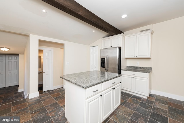 kitchen featuring lofted ceiling with beams, stainless steel fridge with ice dispenser, a kitchen island, and white cabinets