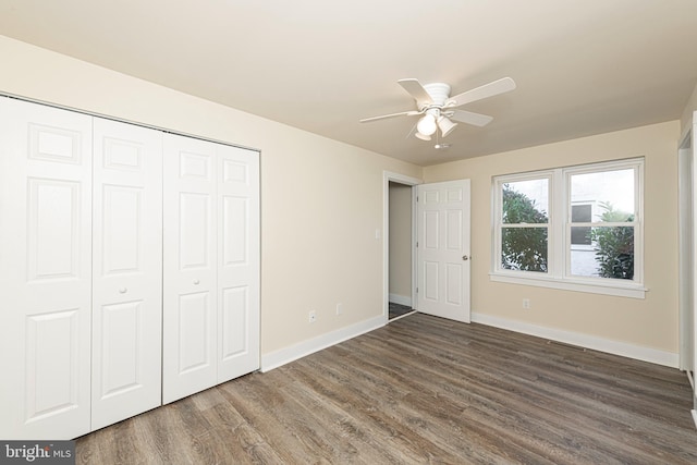 unfurnished bedroom with a closet, dark wood-type flooring, and ceiling fan