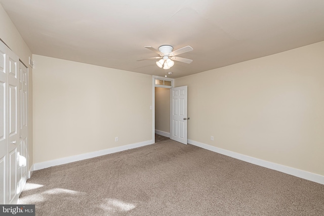 carpeted spare room featuring ceiling fan