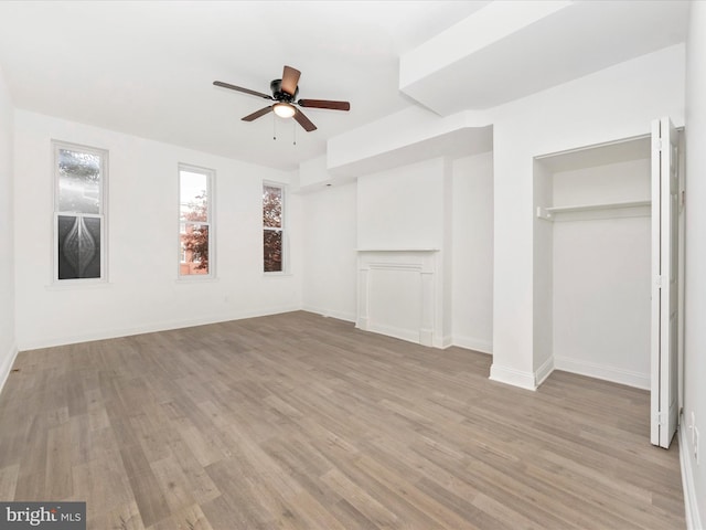 unfurnished bedroom with light hardwood / wood-style floors, a closet, and ceiling fan