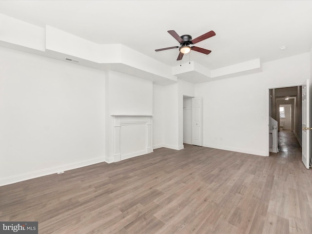 unfurnished living room with ceiling fan and hardwood / wood-style flooring