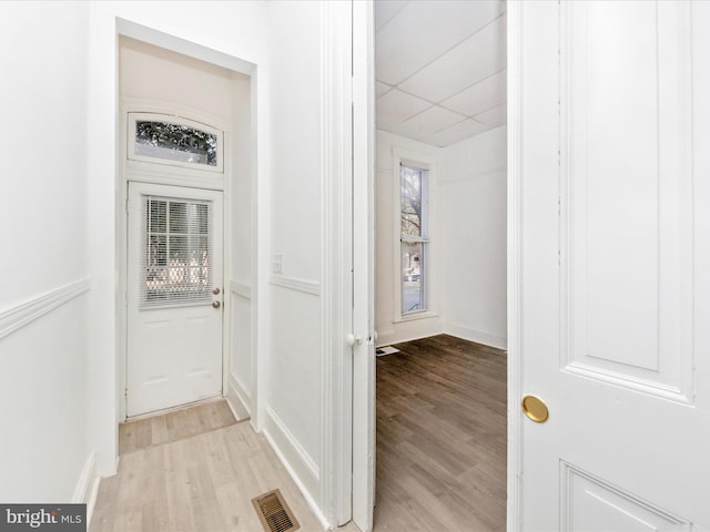 interior space with a paneled ceiling, light hardwood / wood-style flooring, and a wealth of natural light