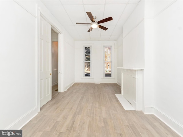 unfurnished living room with ceiling fan, light hardwood / wood-style flooring, and a drop ceiling