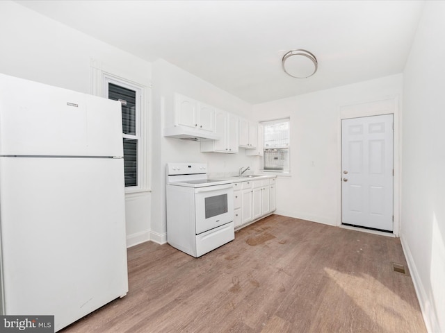 kitchen with white appliances, light hardwood / wood-style floors, sink, and white cabinets