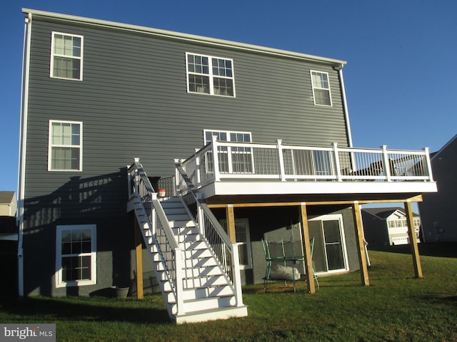 rear view of house featuring a yard and a wooden deck