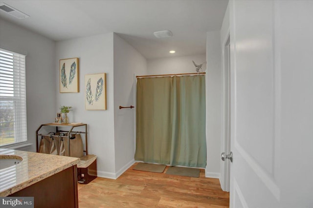 bathroom with hardwood / wood-style floors, plenty of natural light, and vanity