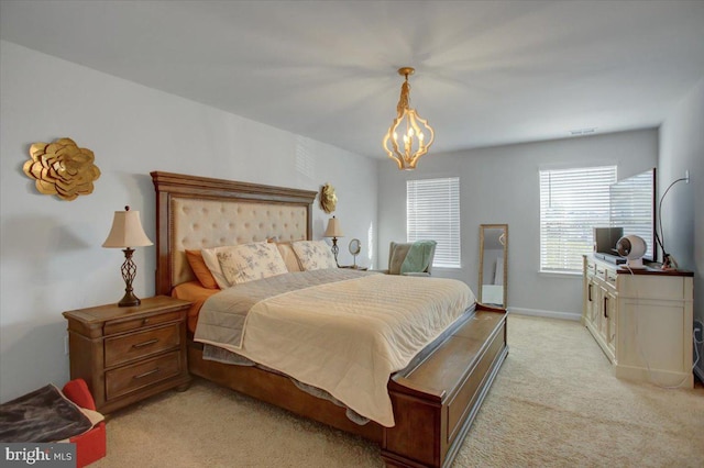 carpeted bedroom with a notable chandelier