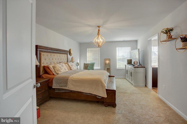 carpeted bedroom with a notable chandelier