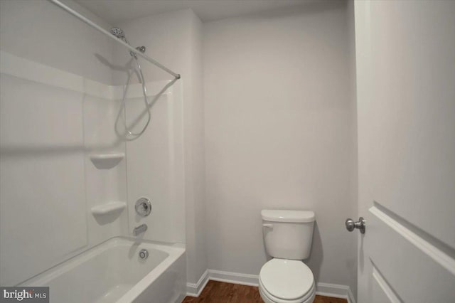 bathroom featuring shower / bathing tub combination, wood-type flooring, and toilet