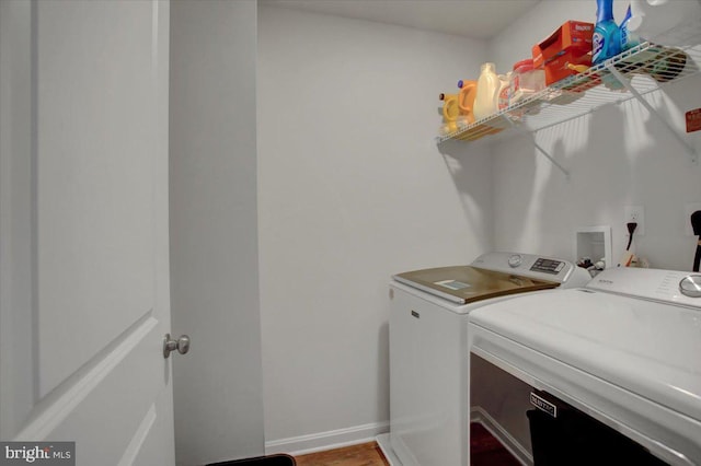 laundry room with hardwood / wood-style flooring and washing machine and clothes dryer