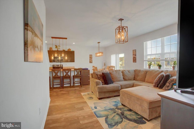 living room with light hardwood / wood-style floors and a chandelier