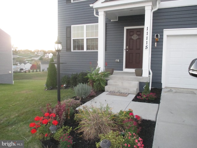 doorway to property with a lawn and a garage