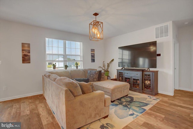 living room with a notable chandelier and light wood-type flooring