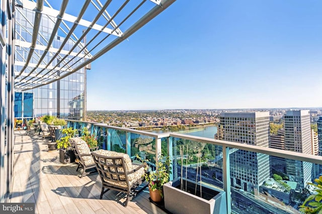 balcony featuring a water view and a pergola