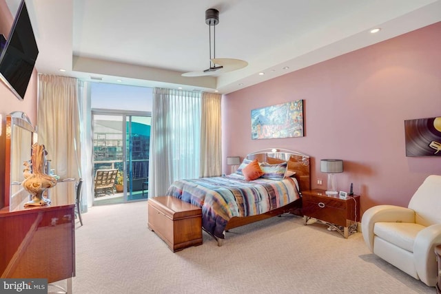 carpeted bedroom featuring a tray ceiling, access to outside, and ceiling fan