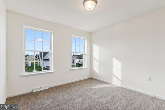 unfurnished room with a wealth of natural light and carpet