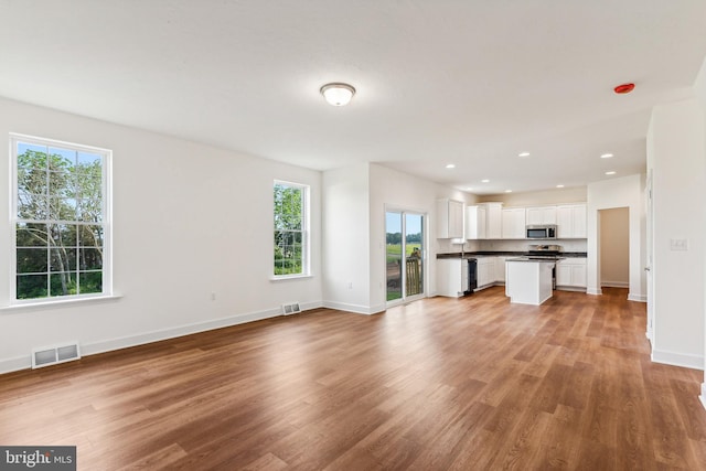 unfurnished living room featuring light hardwood / wood-style flooring and plenty of natural light