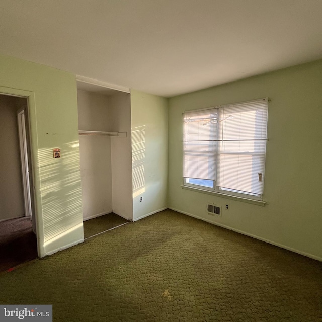 unfurnished bedroom with a closet and dark carpet