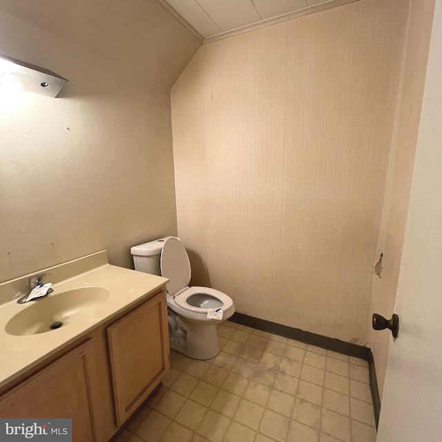 bathroom featuring vanity, vaulted ceiling, and toilet