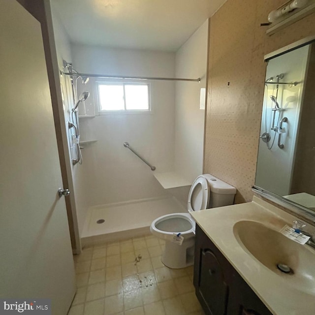 bathroom featuring toilet, walk in shower, and vanity