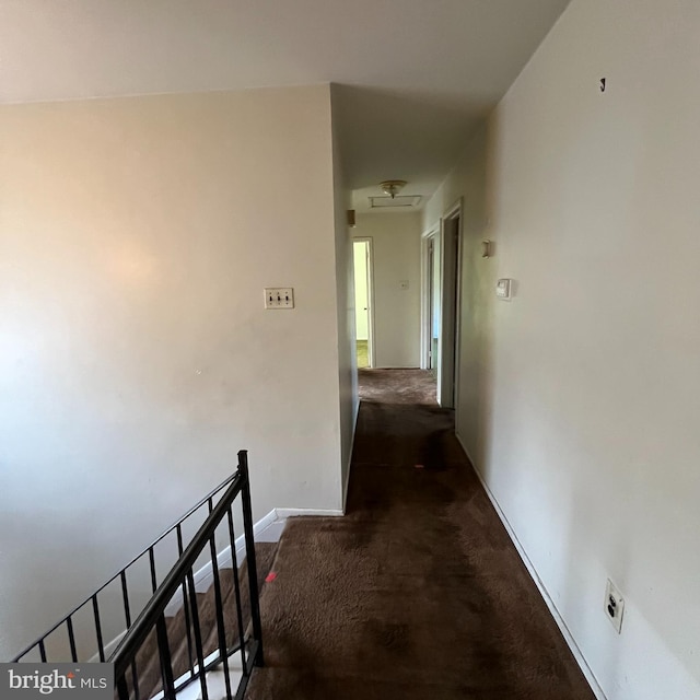 hallway with dark colored carpet