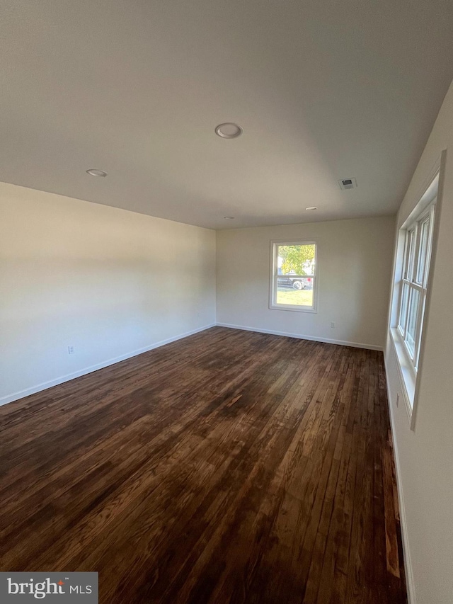 unfurnished room with dark wood-type flooring