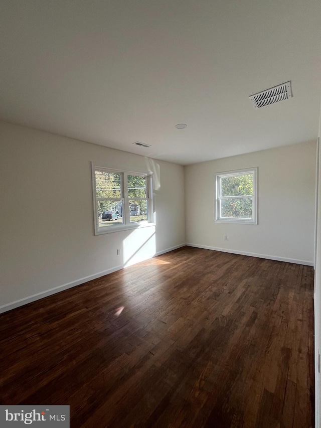 unfurnished room with dark wood-type flooring