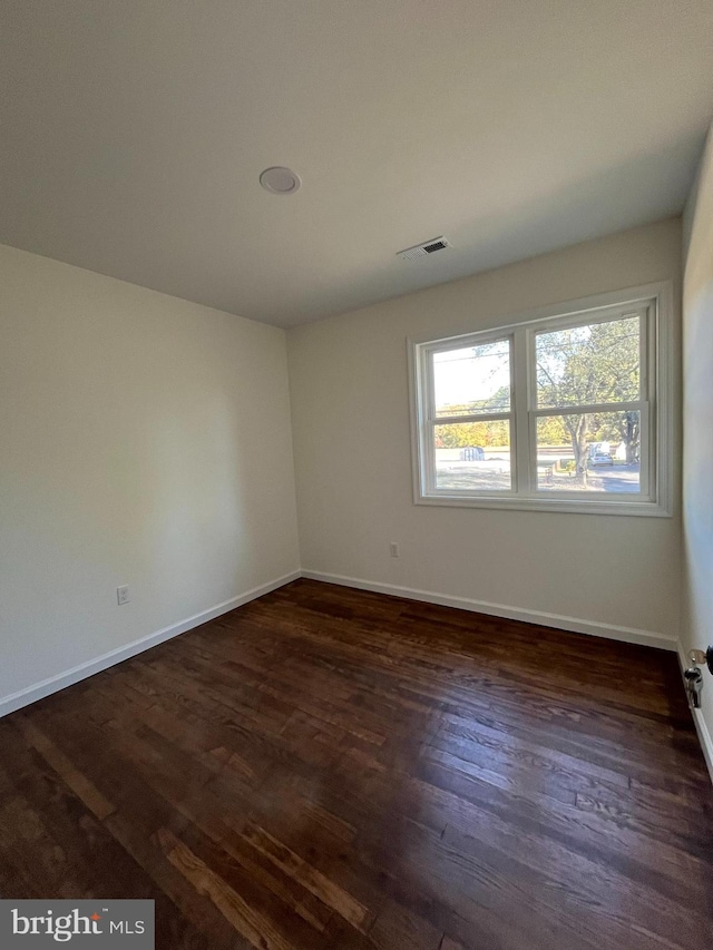 spare room with dark hardwood / wood-style flooring