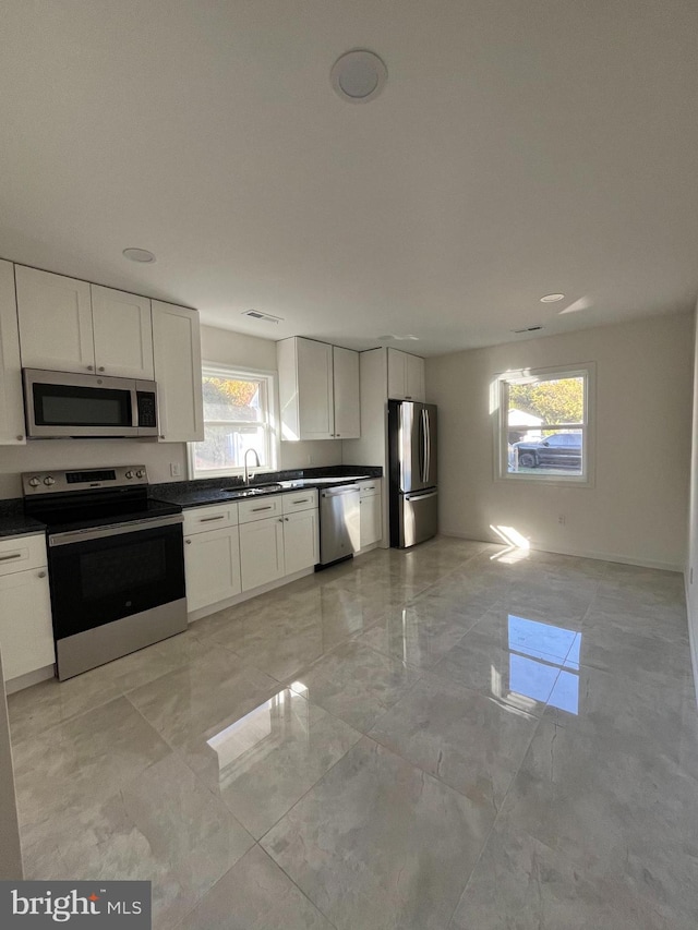 kitchen with white cabinetry, stainless steel appliances, and sink