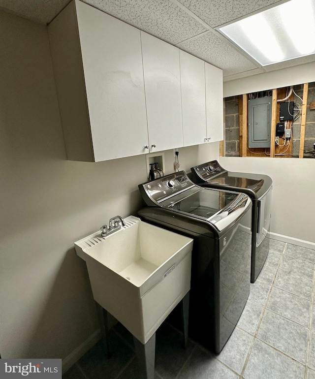 laundry area with cabinets, electric panel, light tile patterned floors, independent washer and dryer, and sink