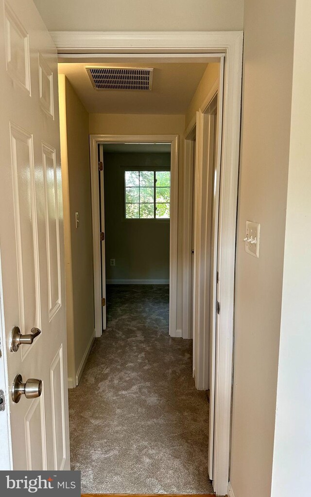 hallway featuring dark carpet