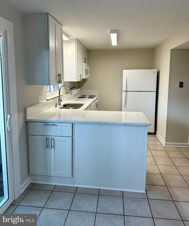 kitchen with white cabinets, light tile patterned flooring, and white appliances